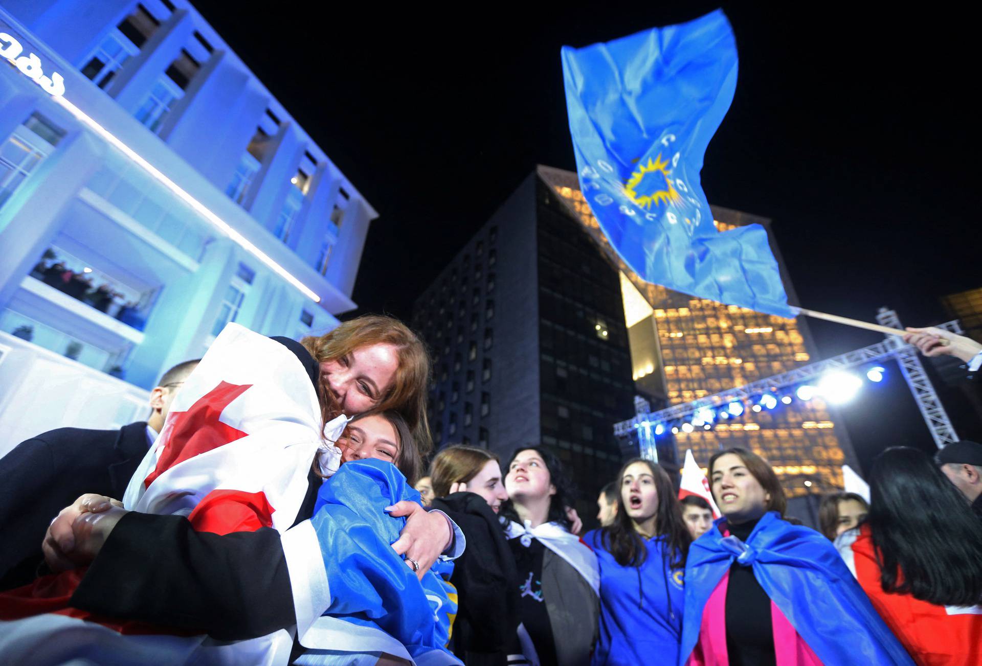 Supporters of the Georgian Dream party celebrate after the announcement of exit poll results in Tbilisi