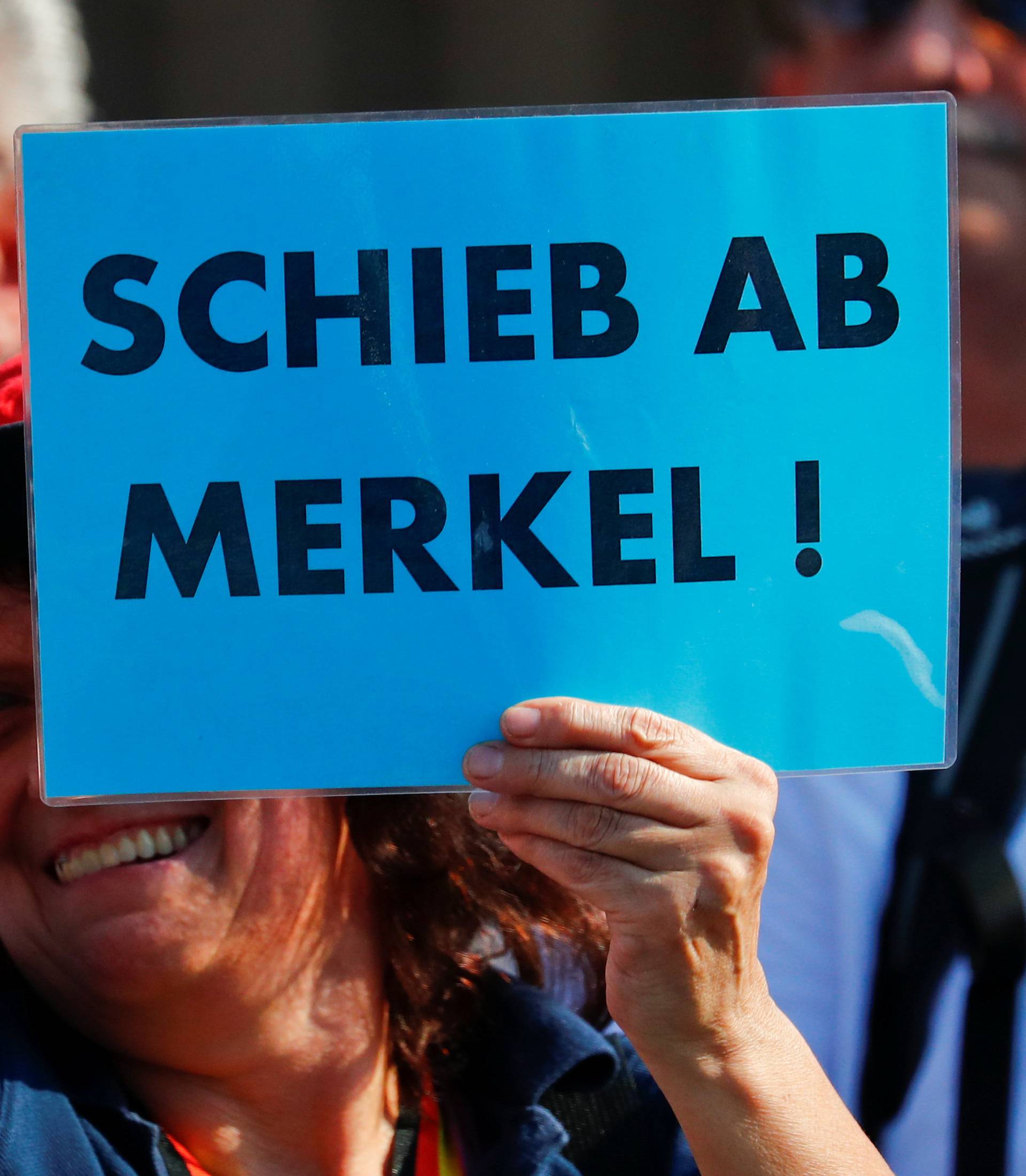 People take part in a protest against German Chancellor Angela Merkel as she visits the state parliament in Dresden