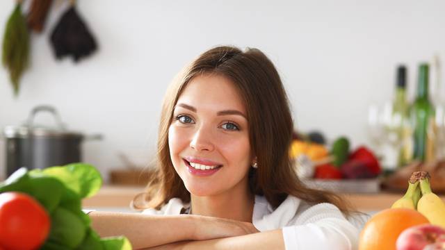 Young woman standing near desk in the kitchen