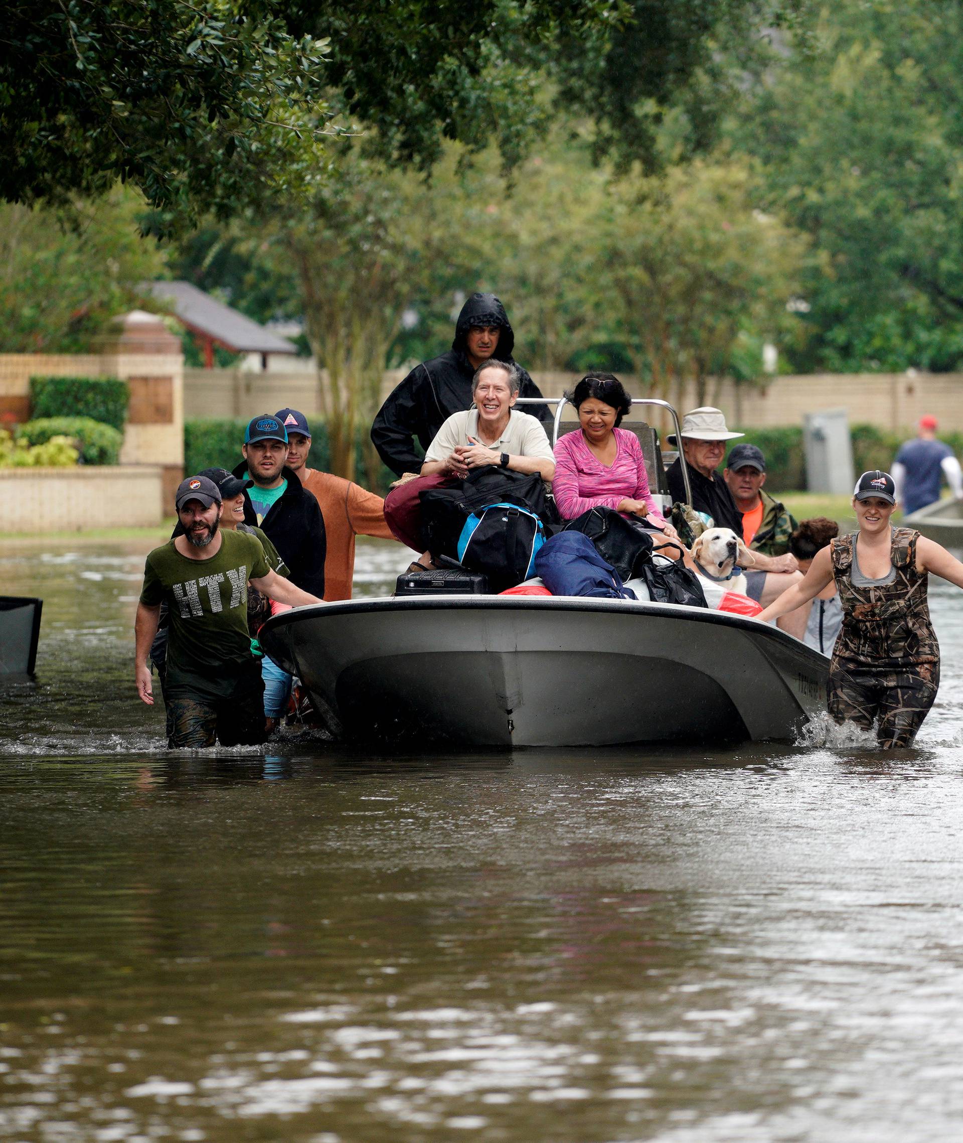 People evacuate by boat from the Hurricane Harvey floodwaters in Houston
