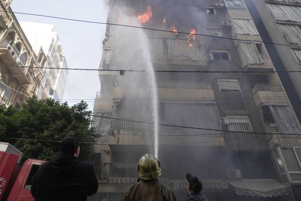 Member of the Lebanese Civil Defence works to extinguish a fire in a building after an Israeli strike on Beirut