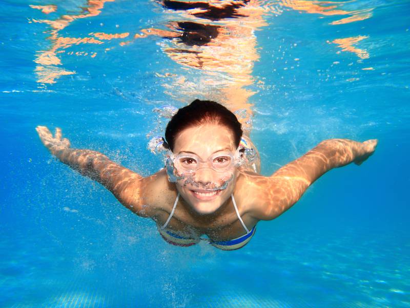 Woman swimming underwater in pool