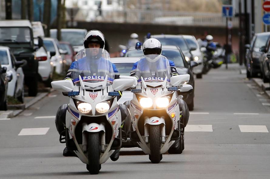French police escort vehicules believed to transport the sister and brother-in-law of Pascal Troadec as they arrive at the courthouse in Nantes