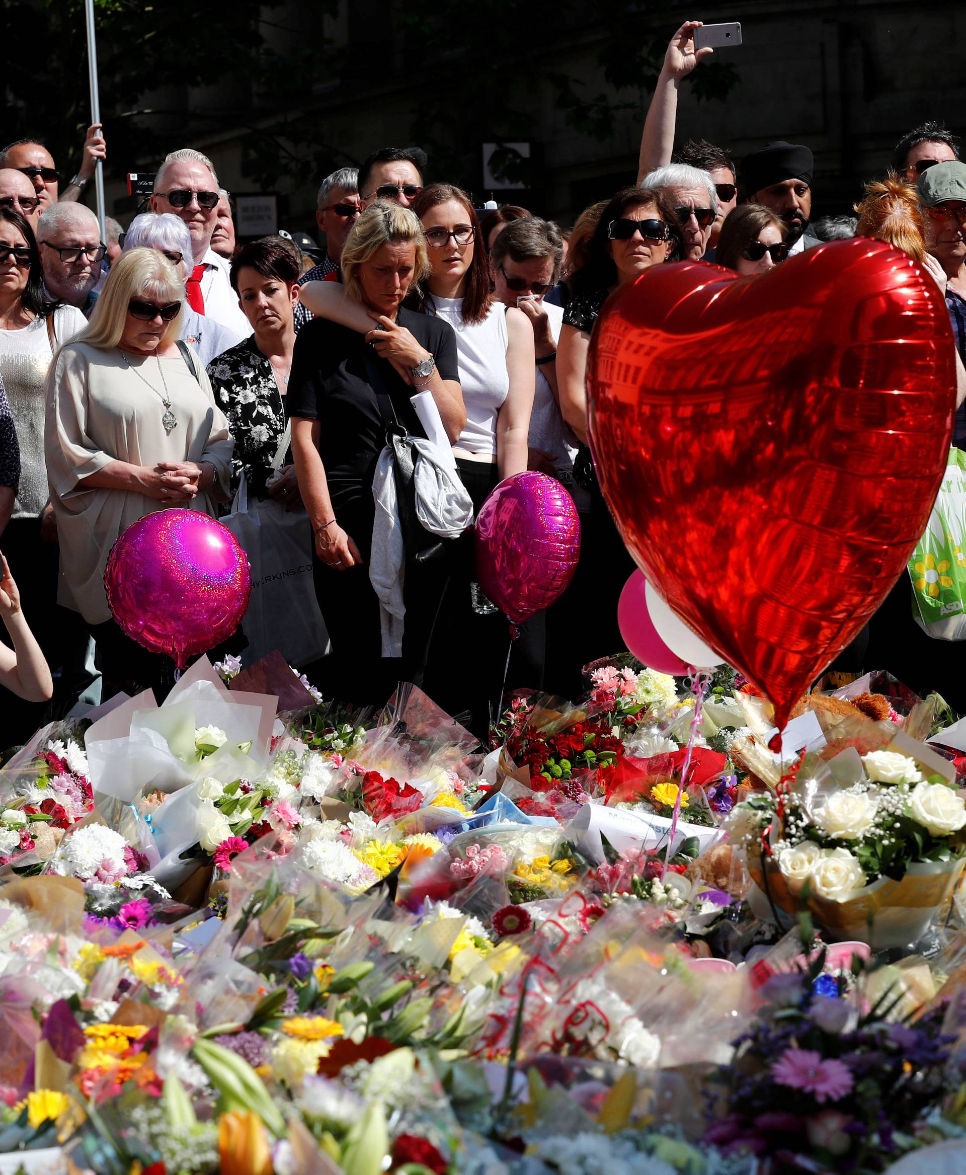 People observe a minute of silence for the victims of the Manchester Arena attack in central Manchester