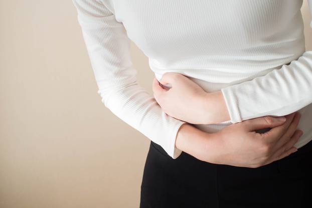 Young,Female,Suffering,Form,Stomach,Ache,On,Gray,Background,W/