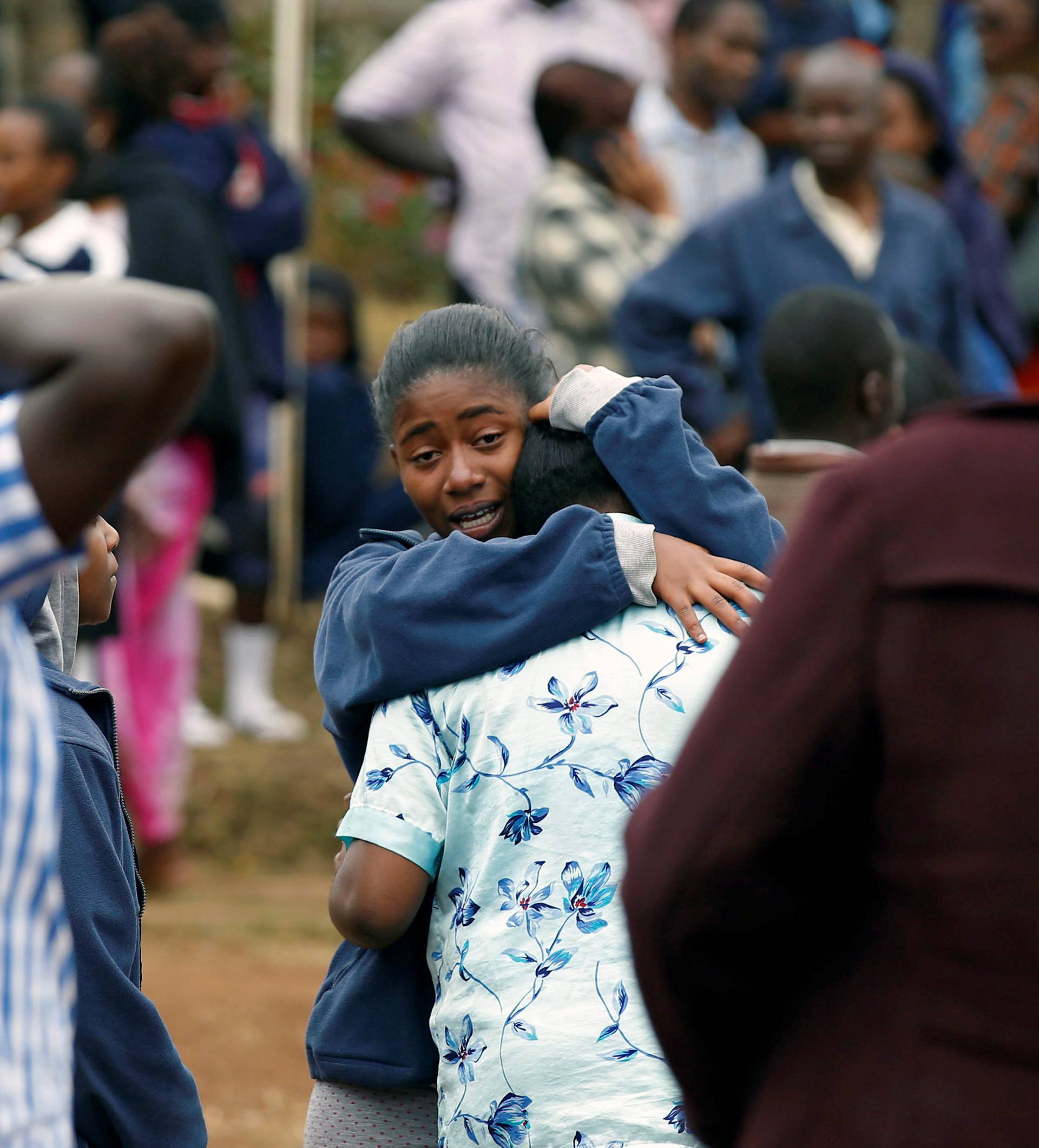 A student embraces her parent following a fire which burnt down one dormitory of Moi Girls school in Nairobi