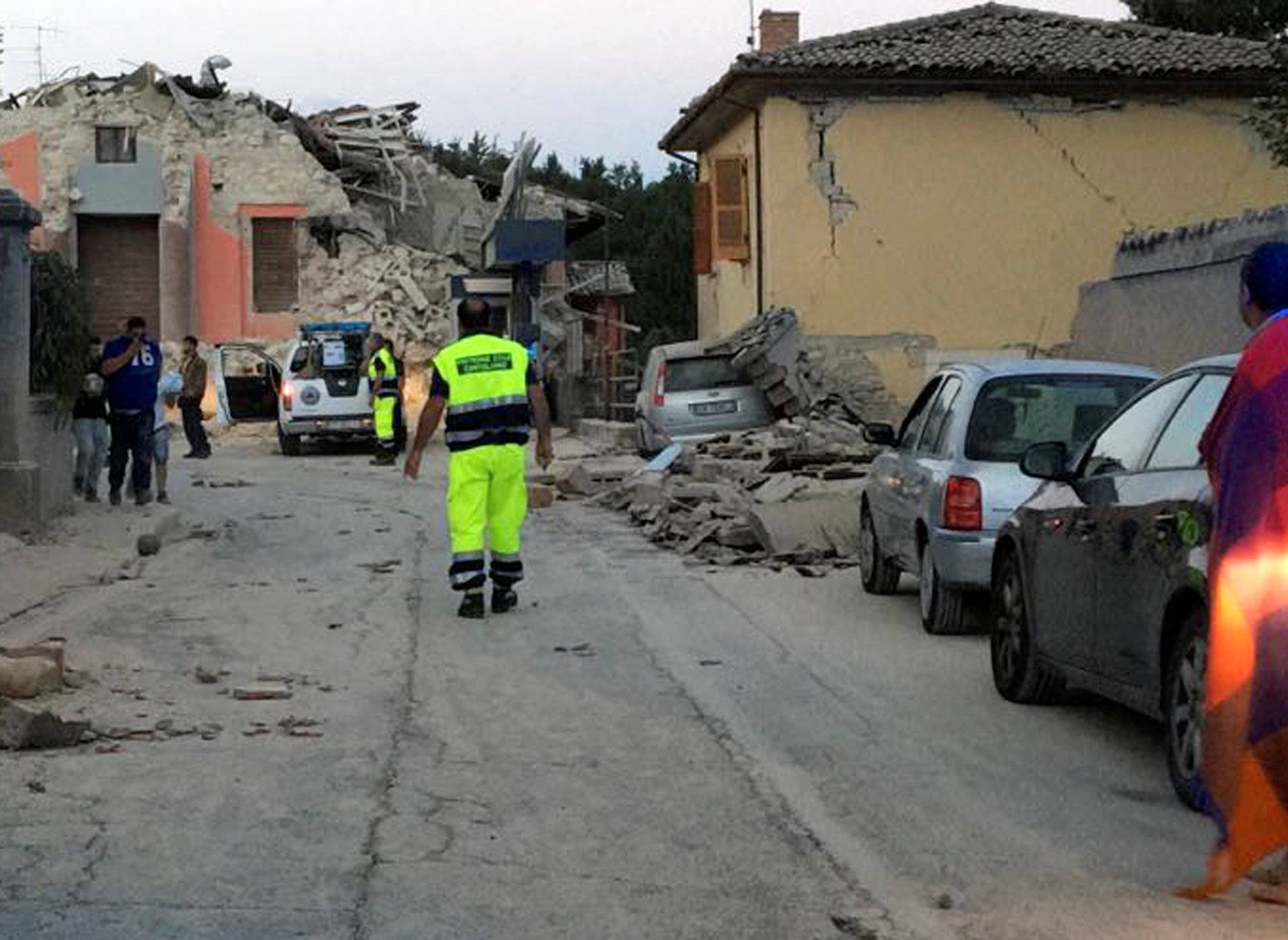 People stand along a road following a quake in Amatrice