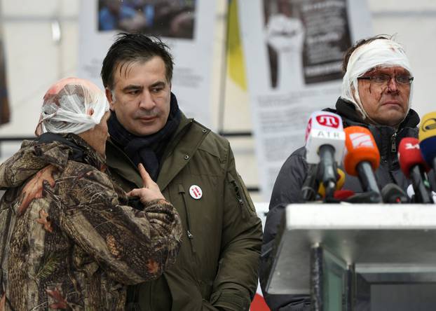 Former Georgian President Mikheil Saakashvili talks to his supporters, who say they were injured in clashes with the police, in front of the Parliament building in Kiev