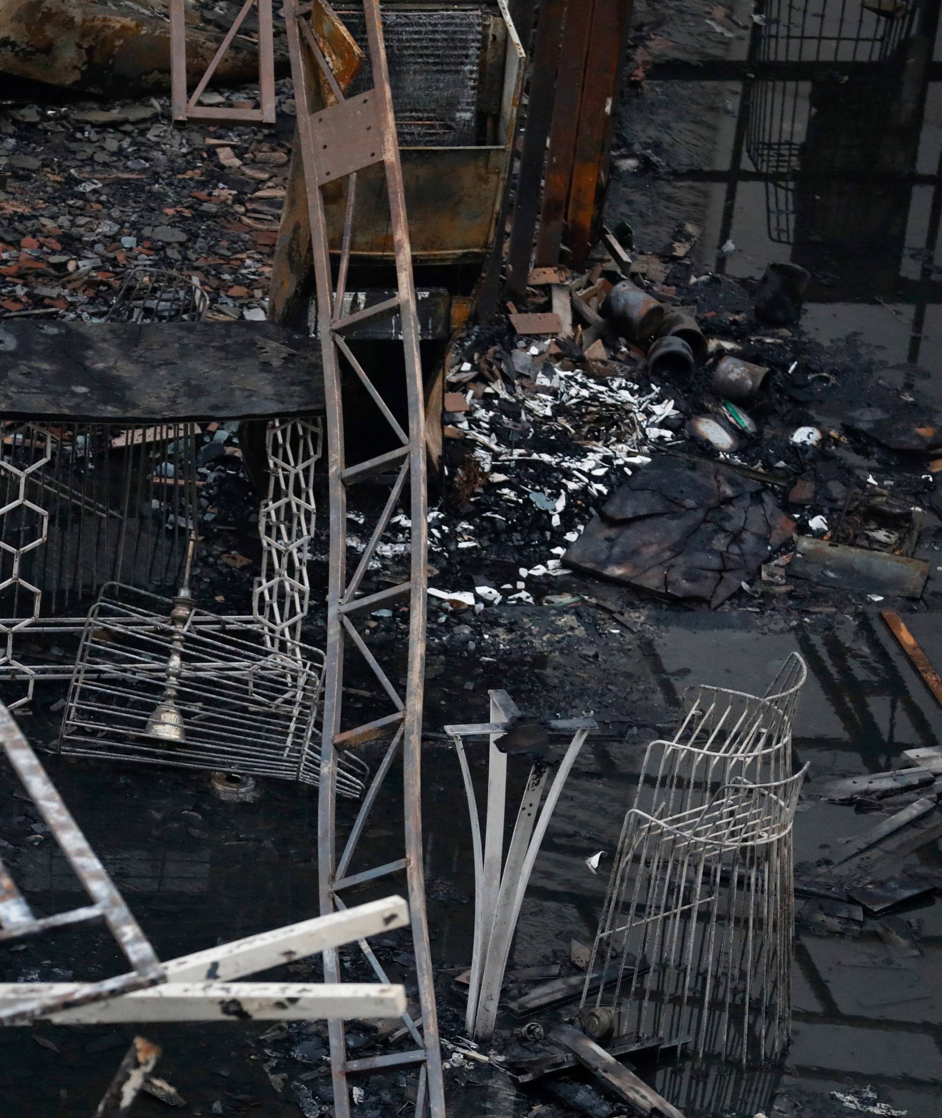 A fire fighter rests amidst debris at a restaurant destroyed in a fire in Mumbai