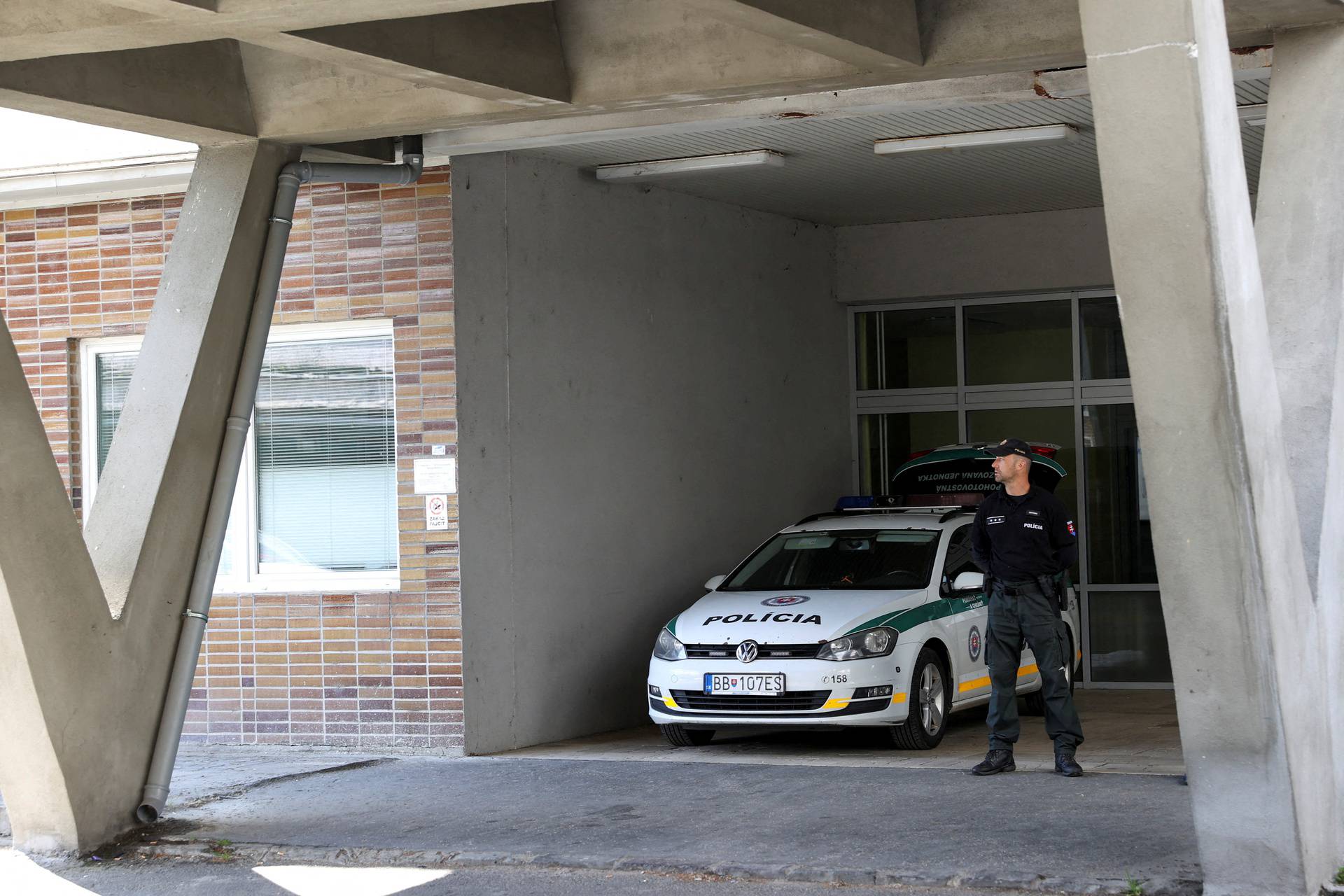 FILE PHOTO: A police officer stands next to a police vehicle parked outside F.D. Roosevelt University Hospital where Slovak Prime Minister Robert Fico was taken after a shooting incident in Handlova, in Banska Bystrica