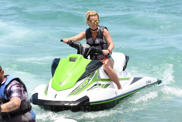 Britney Spears wears a blue bikini as she rides a jet ski in Miami