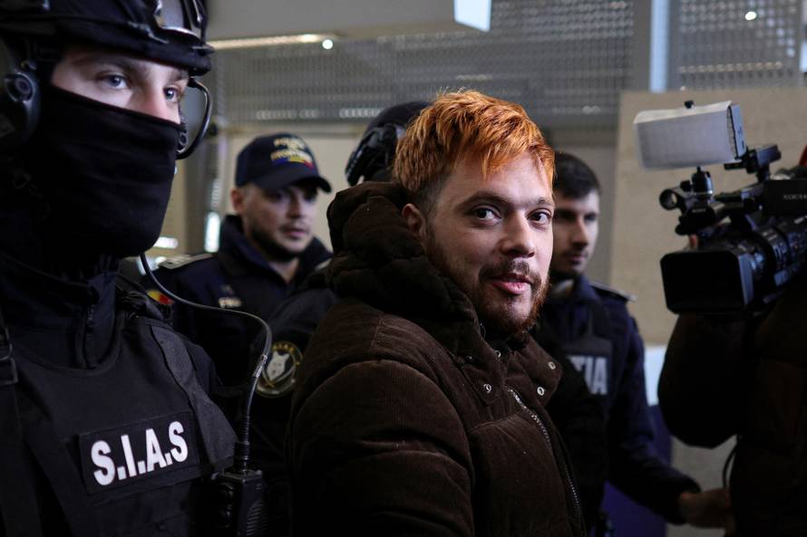 Mohamed Amra is escorted to the tarmac by police officers at Bucharest Henri Coanda International Airport