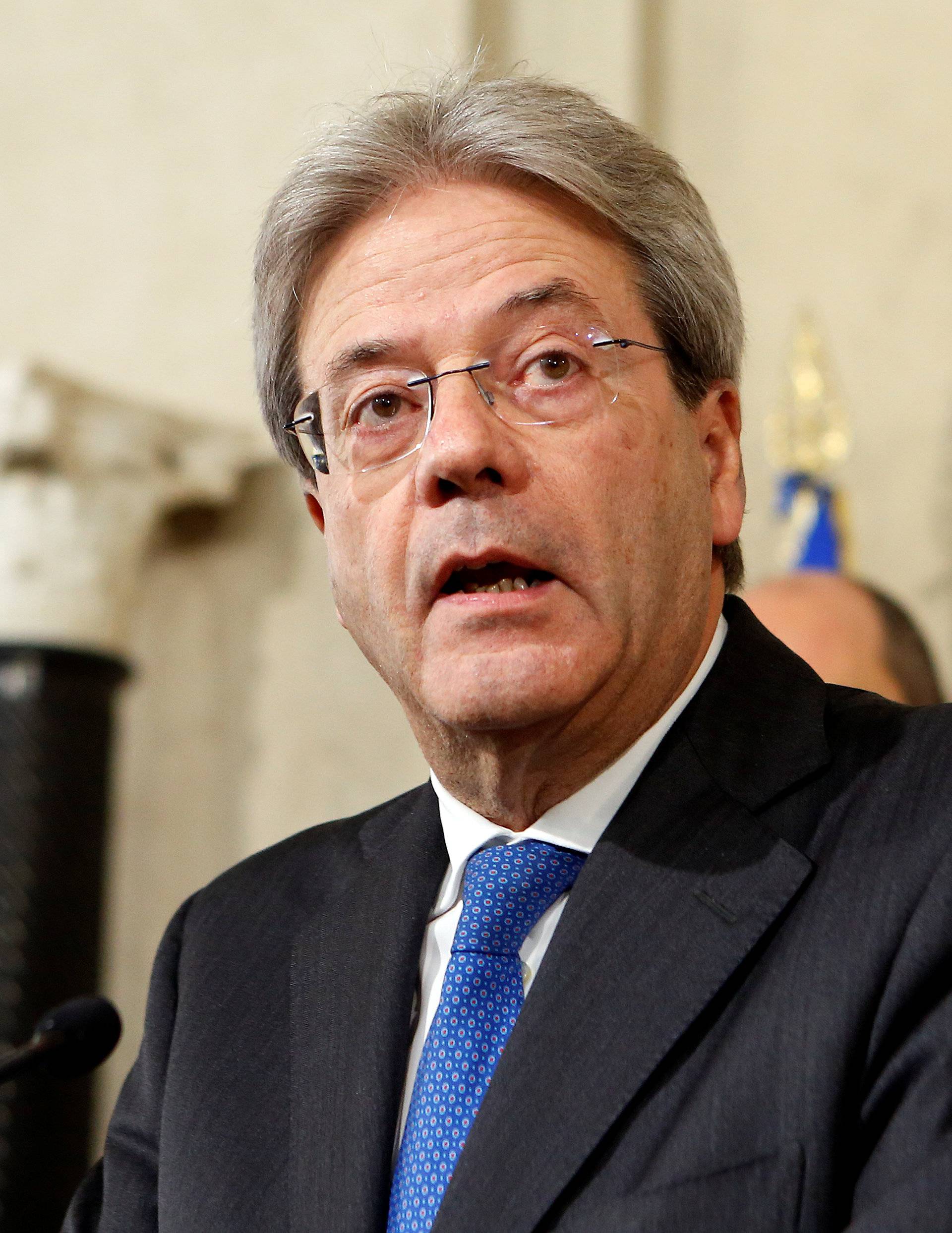 Italy's Foreign Minister Paolo Gentiloni talks to reporters after receiving a mandate to try to form the country's new government, at the Quirinal Palace in Rome