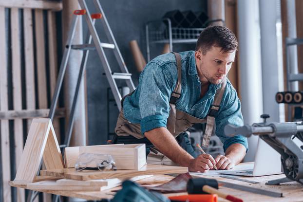 Handsome,Carpenter,Working,On,A,Project,At,Table,With,Tools