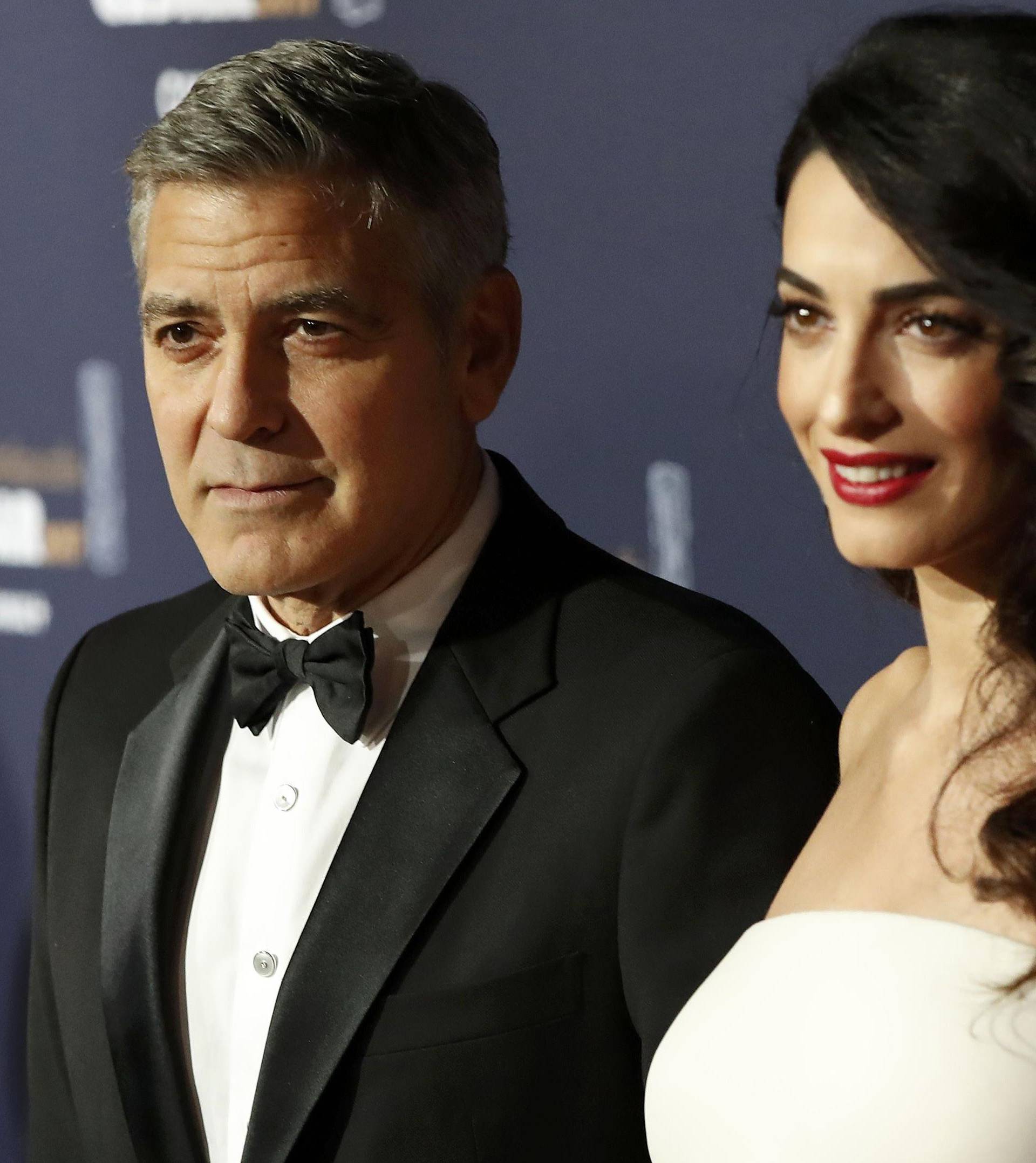 Actor George Clooney and his wife Amal pose as they arrive at the 42nd Cesar Awards ceremony in Paris