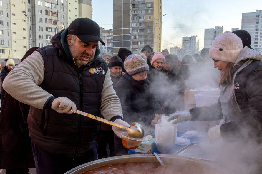 Residents receive food donations in a neighbourhood with electricity and heating outages following recent Russian attacks on Ukraine’s civilian infrastructure during subzero temperatures in Kyiv