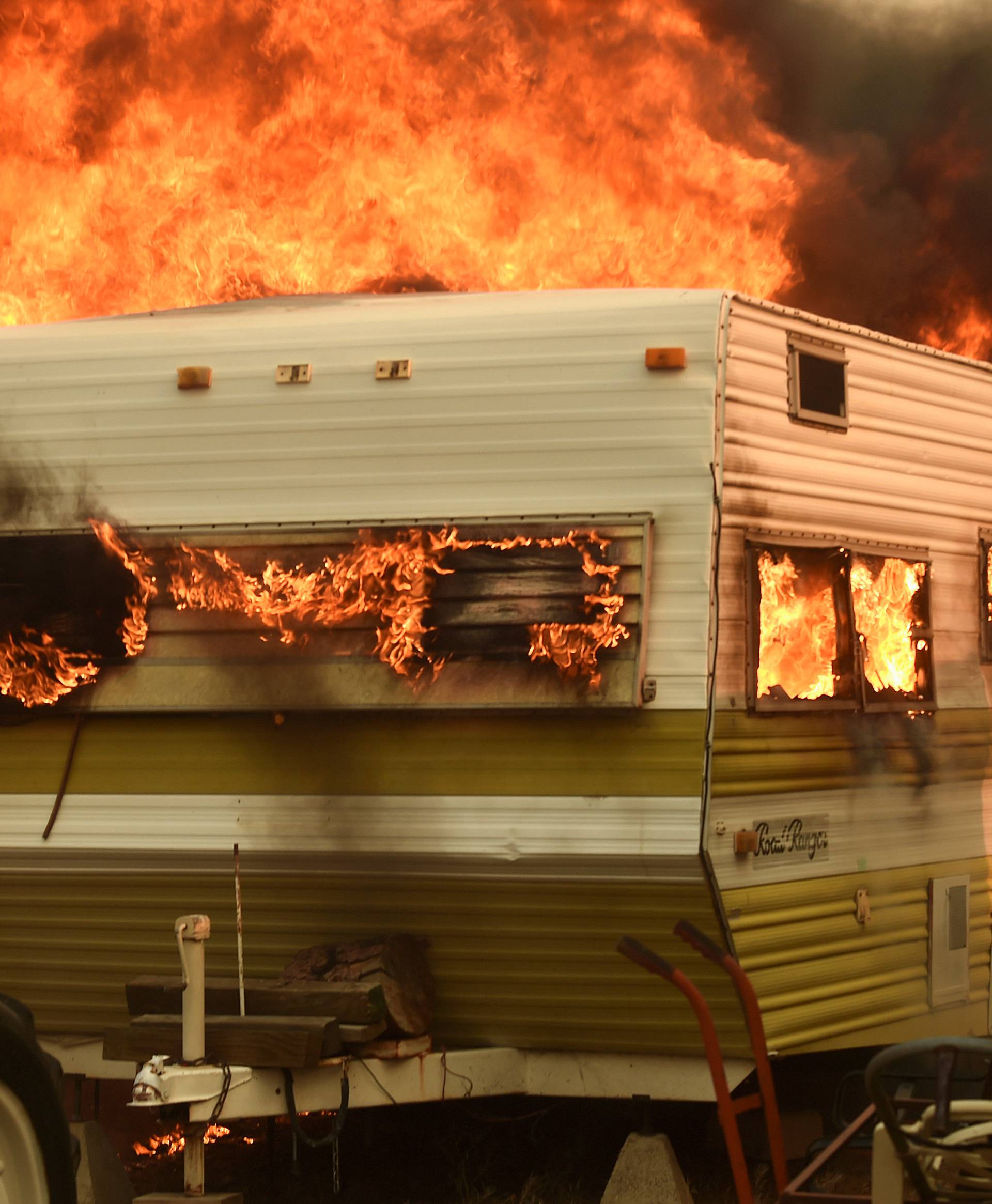 Flames from the Erskine Fire engulf a trailer near Weldon, California