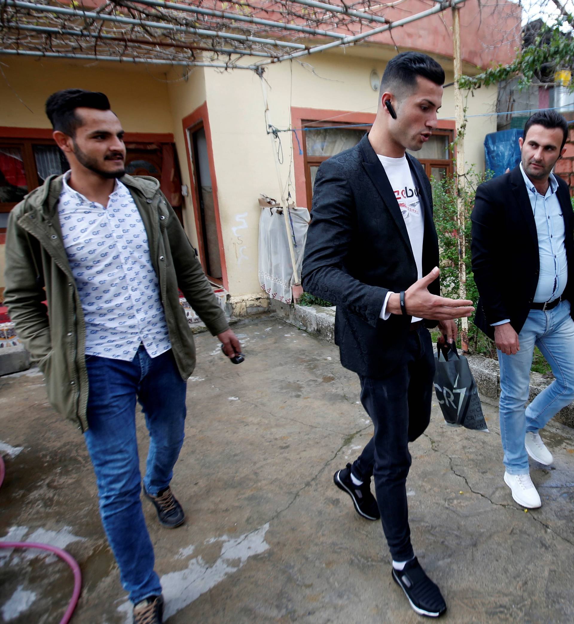 Biwar Abdullah, 25, an Iraqi Kurdish local footballer, who looks like the football player Cristiano Ronaldo, walks with his friends in the district of Soran, northeast of Erbil