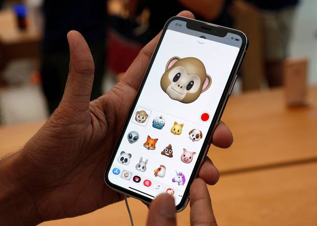 A man tries out the Animoji feature on the iPhone X during its launch at the Apple store in Singapore