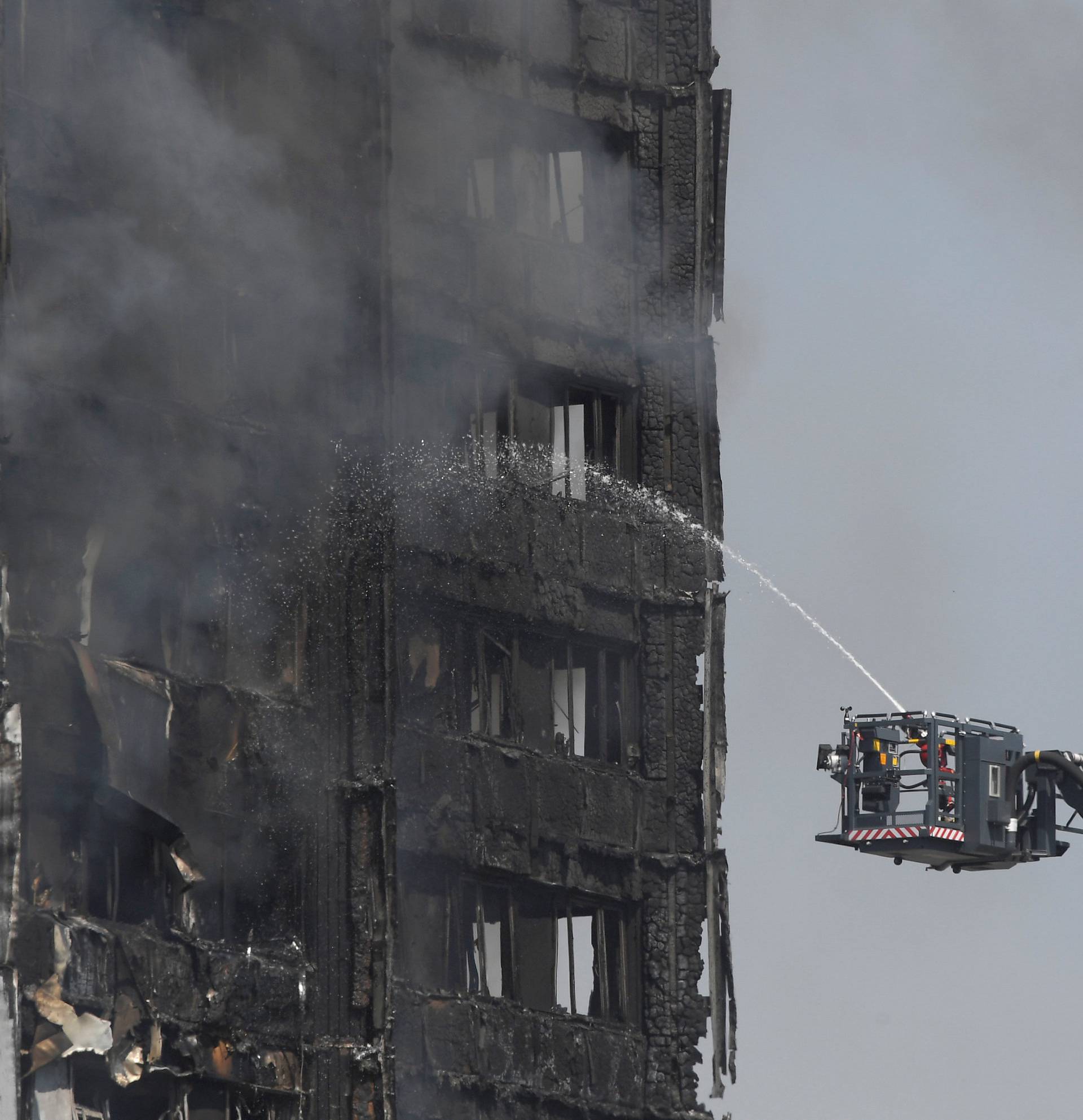 Firefighters direct jets of water onto a tower block severely damaged by a serious fire, in north Kensington, West London