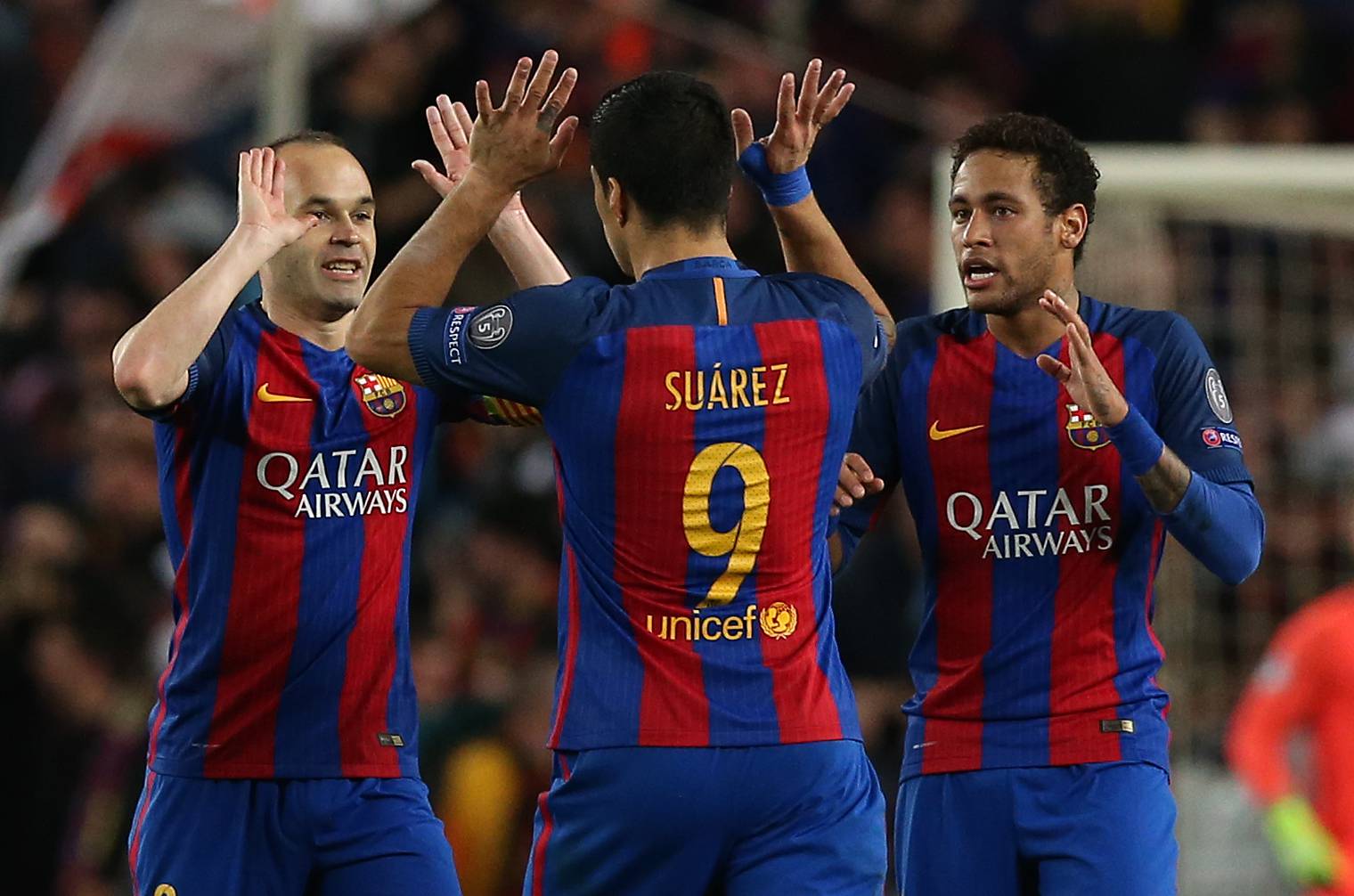 Barcelona's Andres Iniesta celebrates with Luis Suarez and Neymar after Paris Saint-Germain's Layvin Kurzawa scored an own goal and their second goal