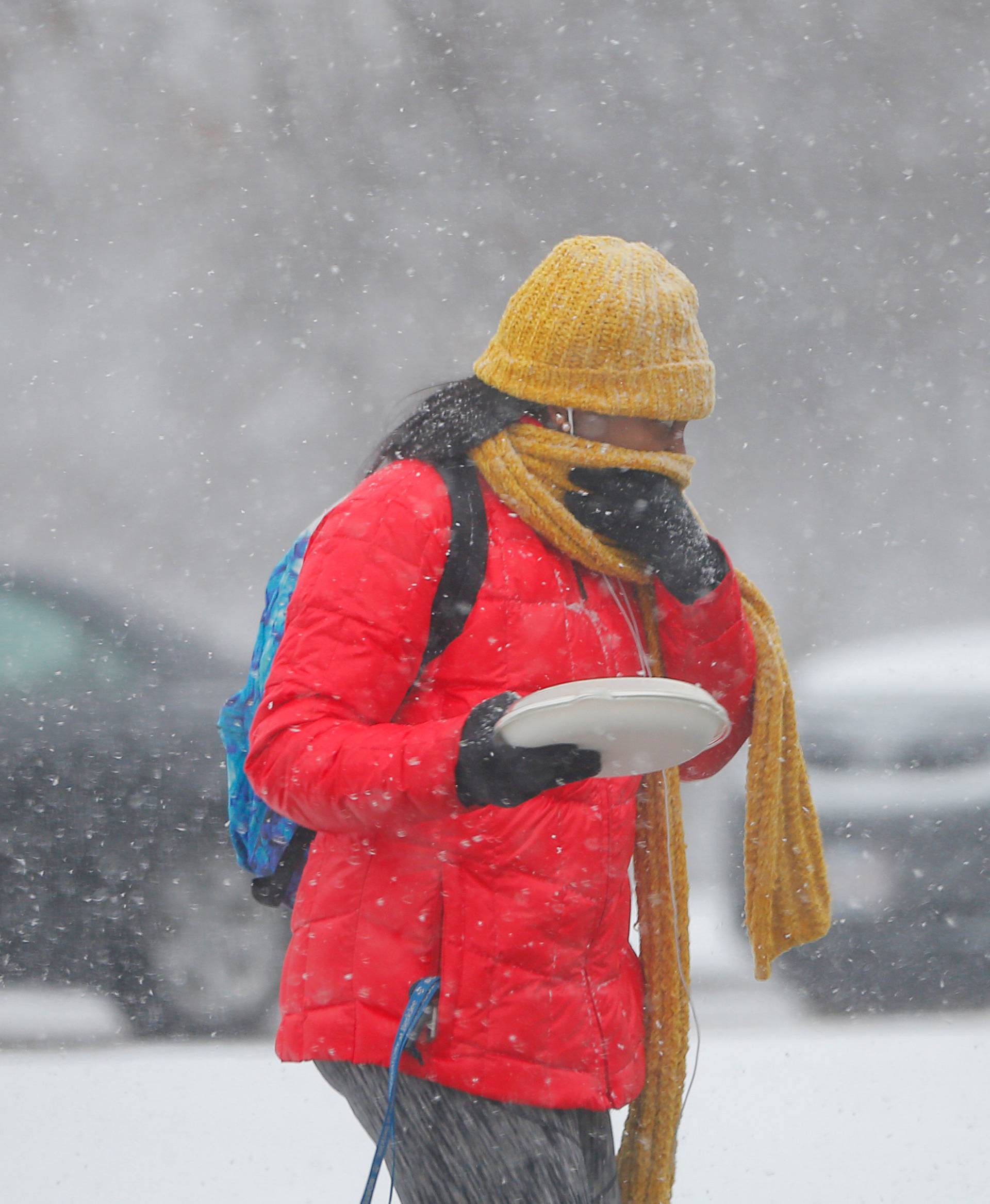 A pedestrian crosses the street during a snow storm in Boston