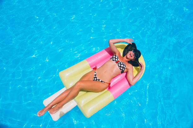 Woman,Lying,On,Water,Matrass,In,The,Pool