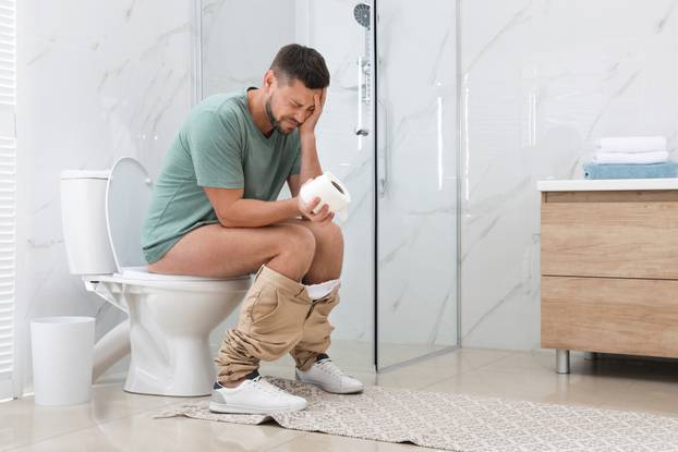 Man,Suffering,From,Hemorrhoid,On,Toilet,Bowl,In,Rest,Room