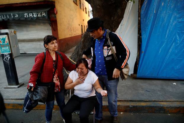 People react after an earthquake shook buildings in Mexico City