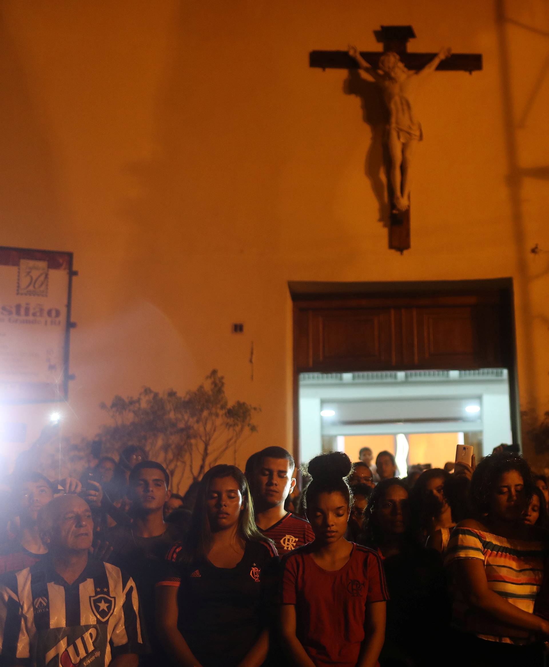 People react during a mass in memory of the victims of Flamengo club's training center deadly fire in Rio de Janeiro
