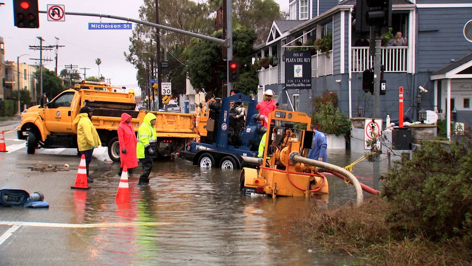 Workers pump flood water from the street surrounding the Inn at Playa del Rey, after heavy rains hit Southern California