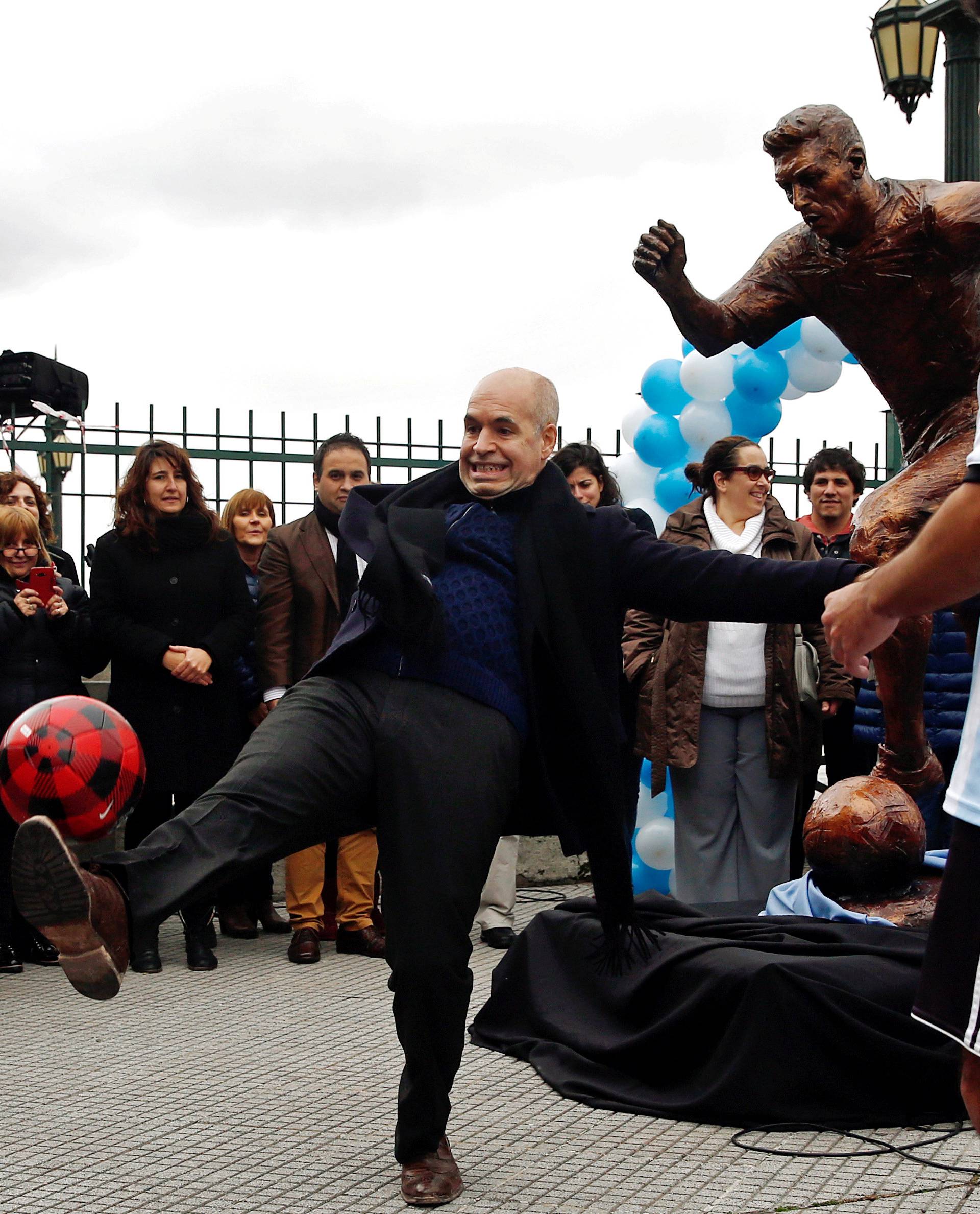 Buenos Aires City Mayor Rodriguez Larreta kicks a ball in front of the statue of Argentina's soccer player Messi after it was unveiled in Buenos Aires