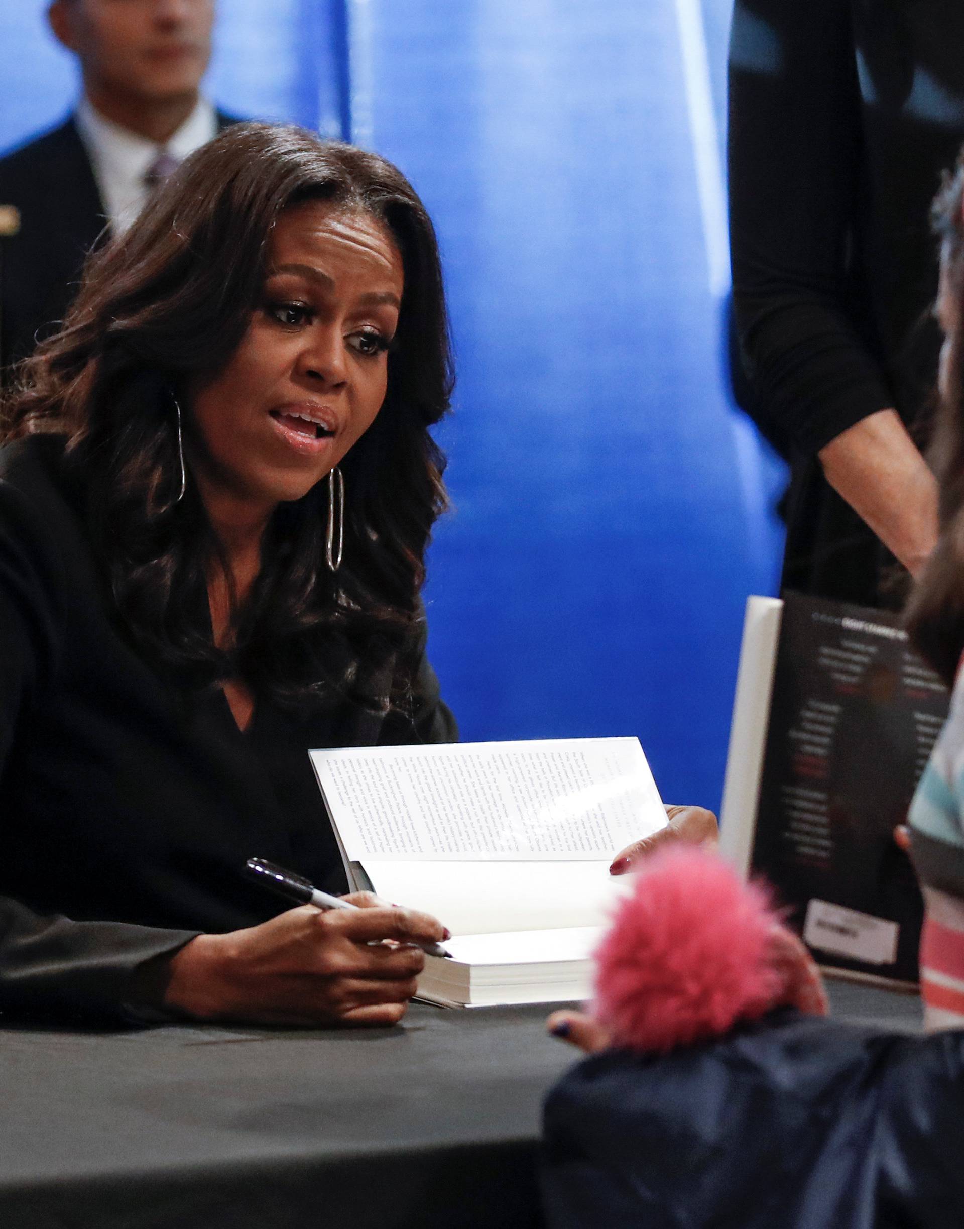 Former first lady Michelle Obama signs copies of her memoir "Becoming" at the Seminary Co-op Bookstore in Chicago