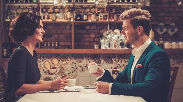 Stylish wealthy couple having desert and coffee together in a restaurant.