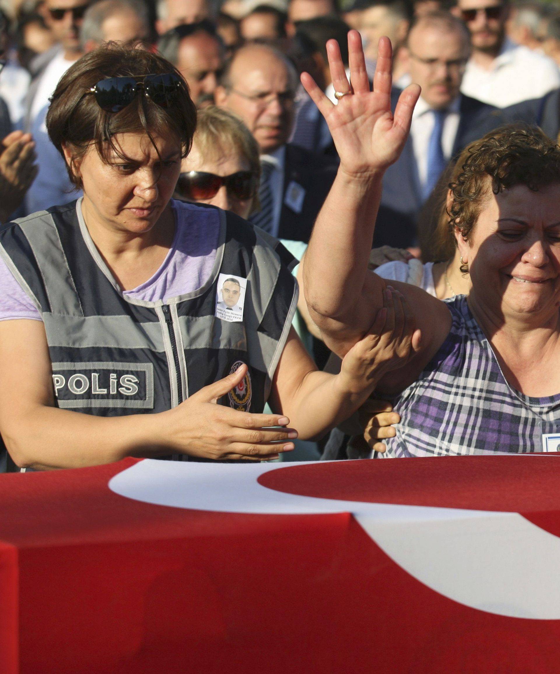 Women mourn over the coffin holding body of police officer Nedip Cengiz Eker during a funeral ceremony in Marmaris