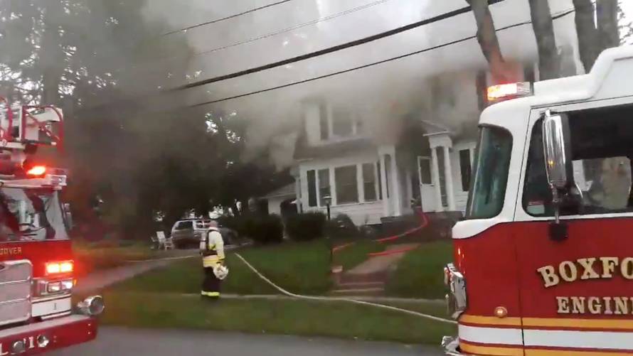 Still image from social media video footage by Boston Sparks shows firefighters working near a building emitting smoke after explosions in North Andover, Massachusetts