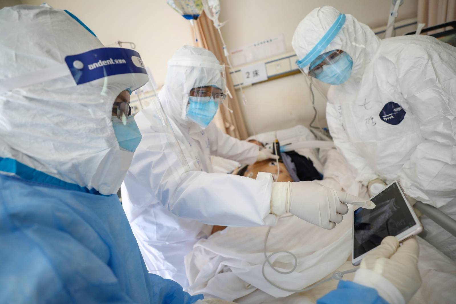 Medical workers in protective suits attend to a patient inside an isolated ward of Wuhan Red Cross Hospital in Wuhan, the epicentre of the novel coronavirus outbreak