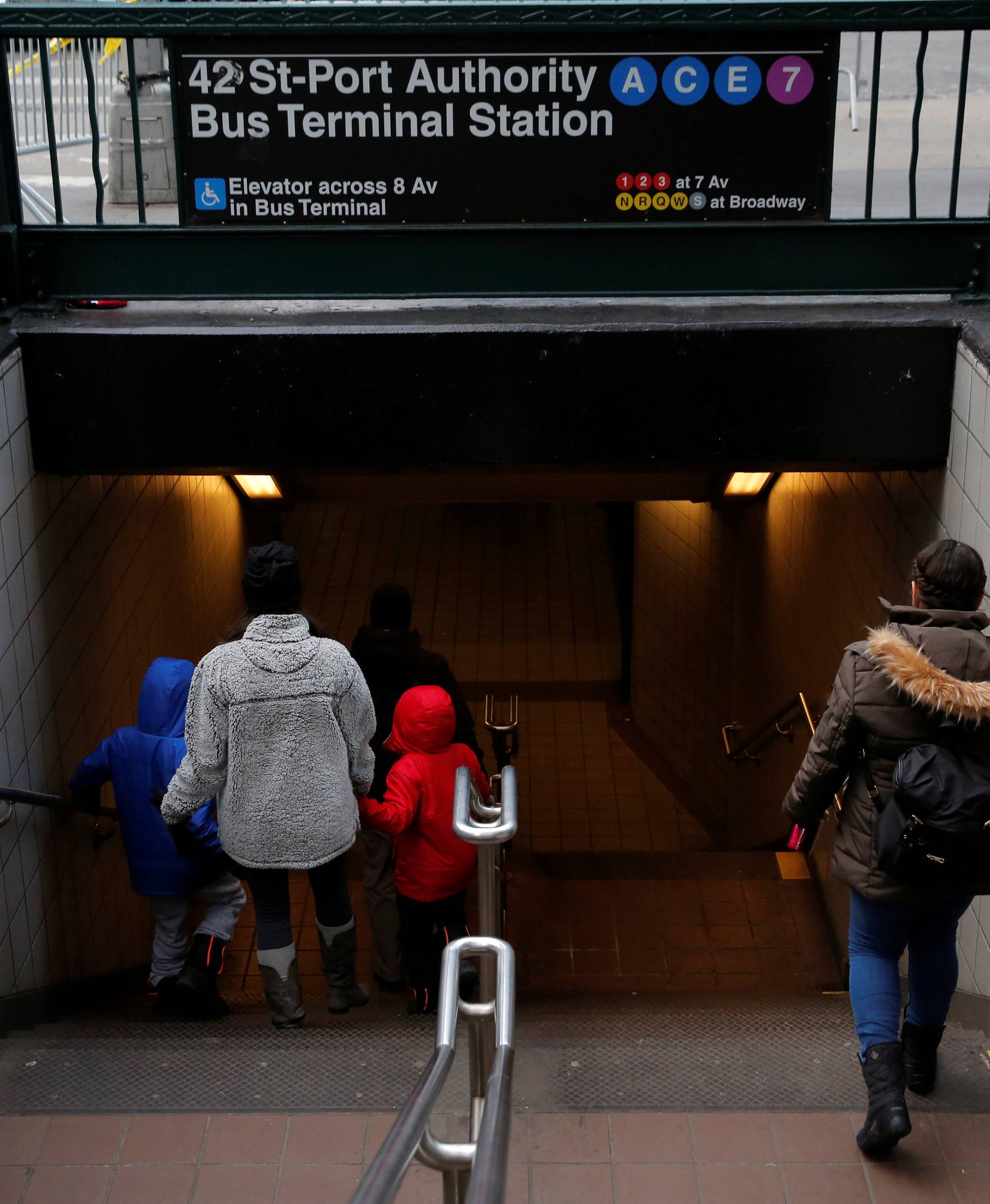 People enter the subway station by the New York Port Authority Bus Terminal following an attempted detonation during the morning rush hour, in New York City