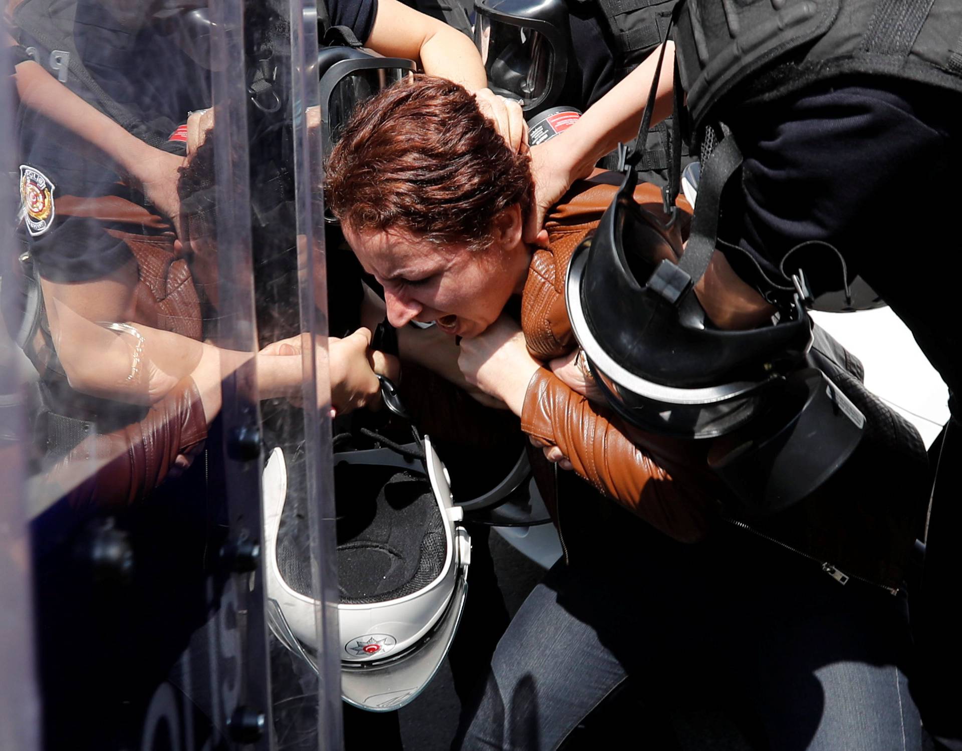 Turkish riot police detain a protester as she and others attempted to defy a ban and march on Taksim Square to celebrate May Day in Istanbul
