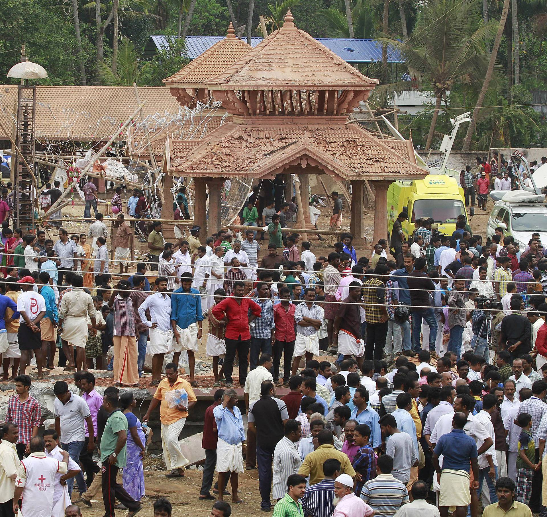 People gather inside the compound of a temple after a fire broke out at a temple in Kollam in the southern state of Kerala
