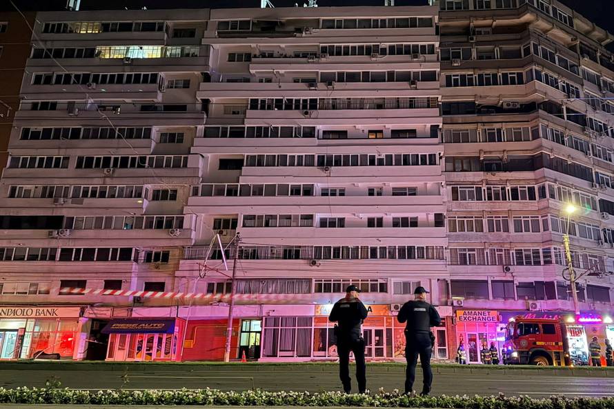 Firefighters and law enforcement work on the site of an explosion at a residential block of flats following a drone hit close to the border with Ukraine