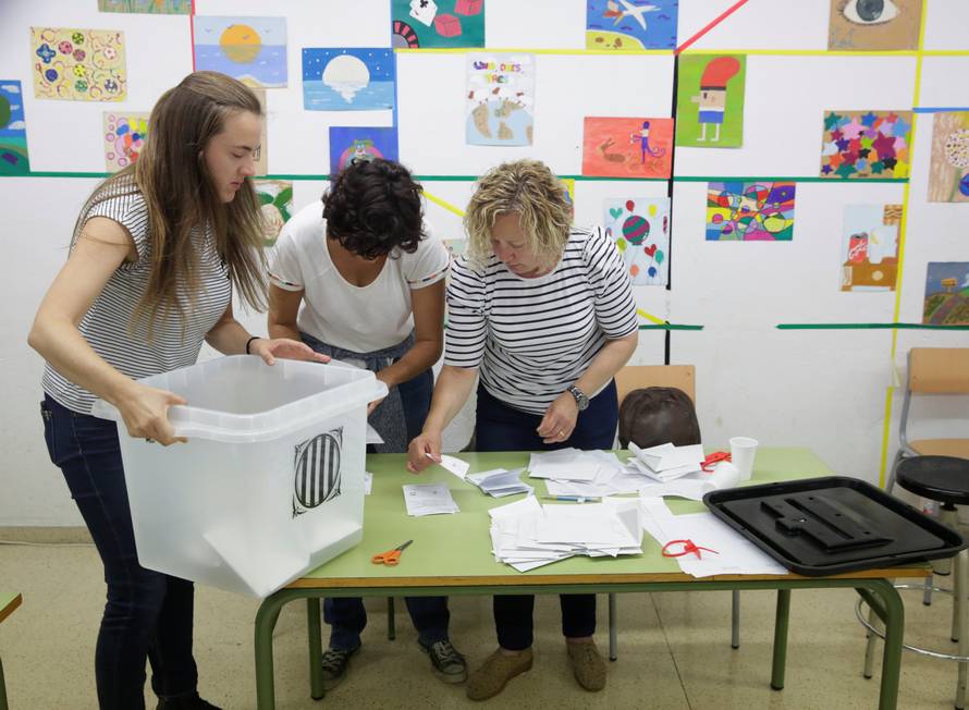 Poll workers count ballots after polls closed at a polling station for the banned independence referendum in Tarragona
