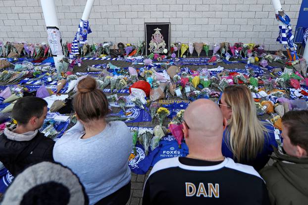 Leicester City football fans pay their respects outside the football stadium, after the helicopter of the club owner Thai businessman Vichai Srivaddhanaprabha crashed when leaving the ground on Saturday evening after the match, in Leicester