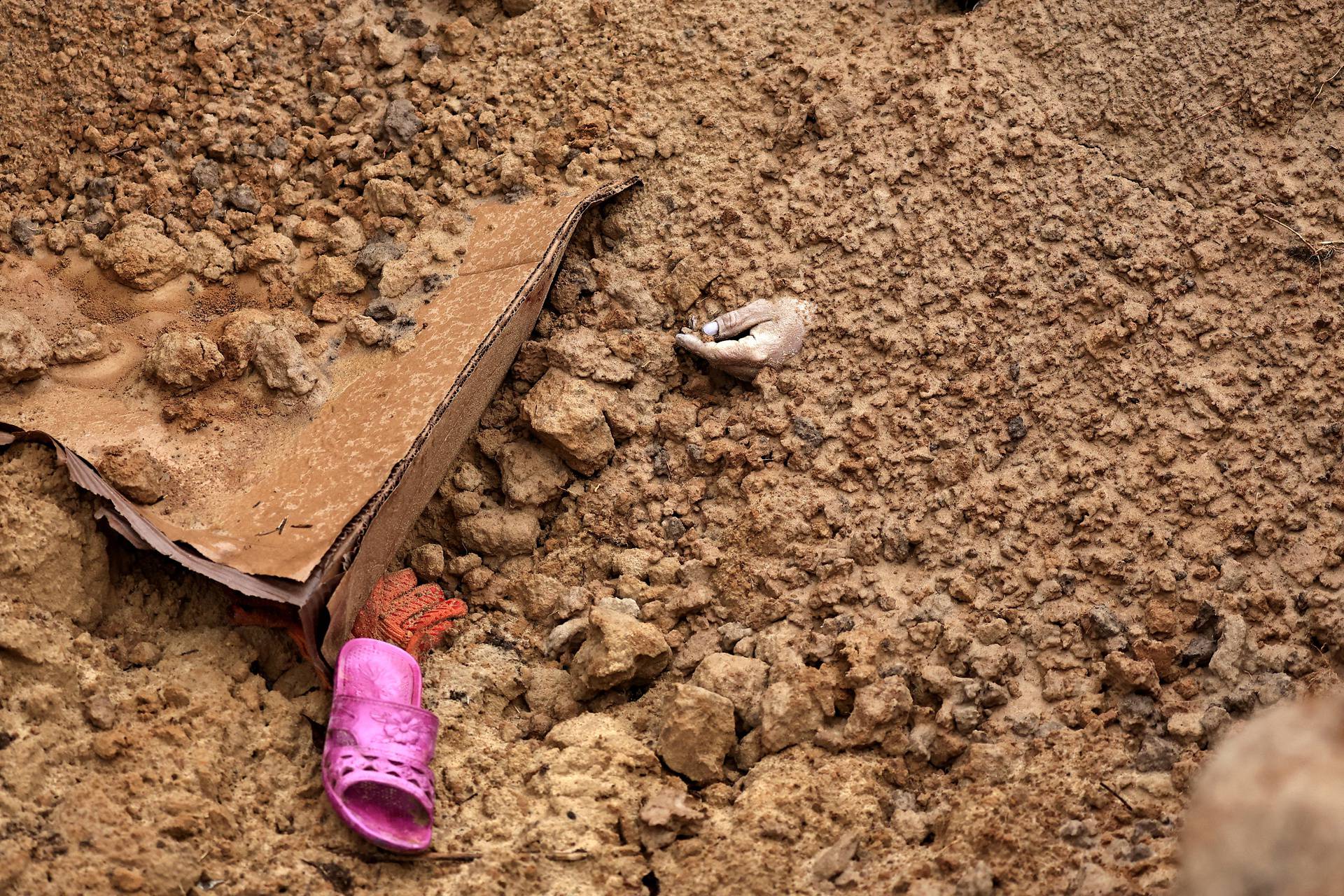 A body of a civilian, who according to residents was killed by Russian army soldiers and then buried along with others in one grave, is seen, amid Russia's invasion of Ukraine, in Bucha