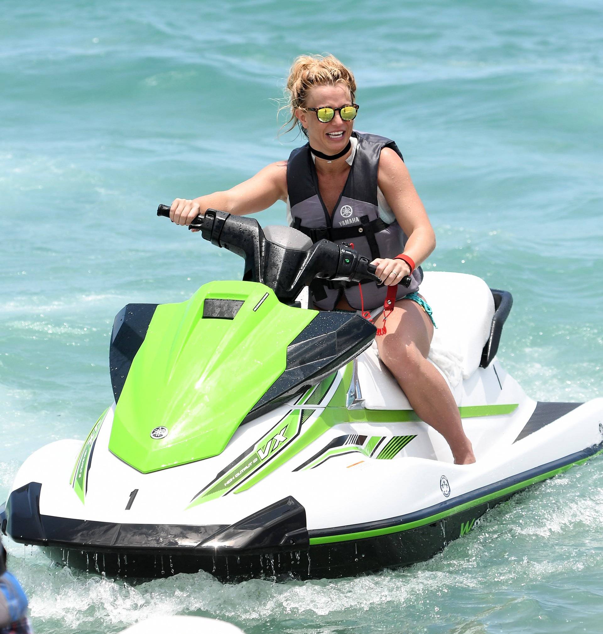 Britney Spears wears a blue bikini as she rides a jet ski in Miami