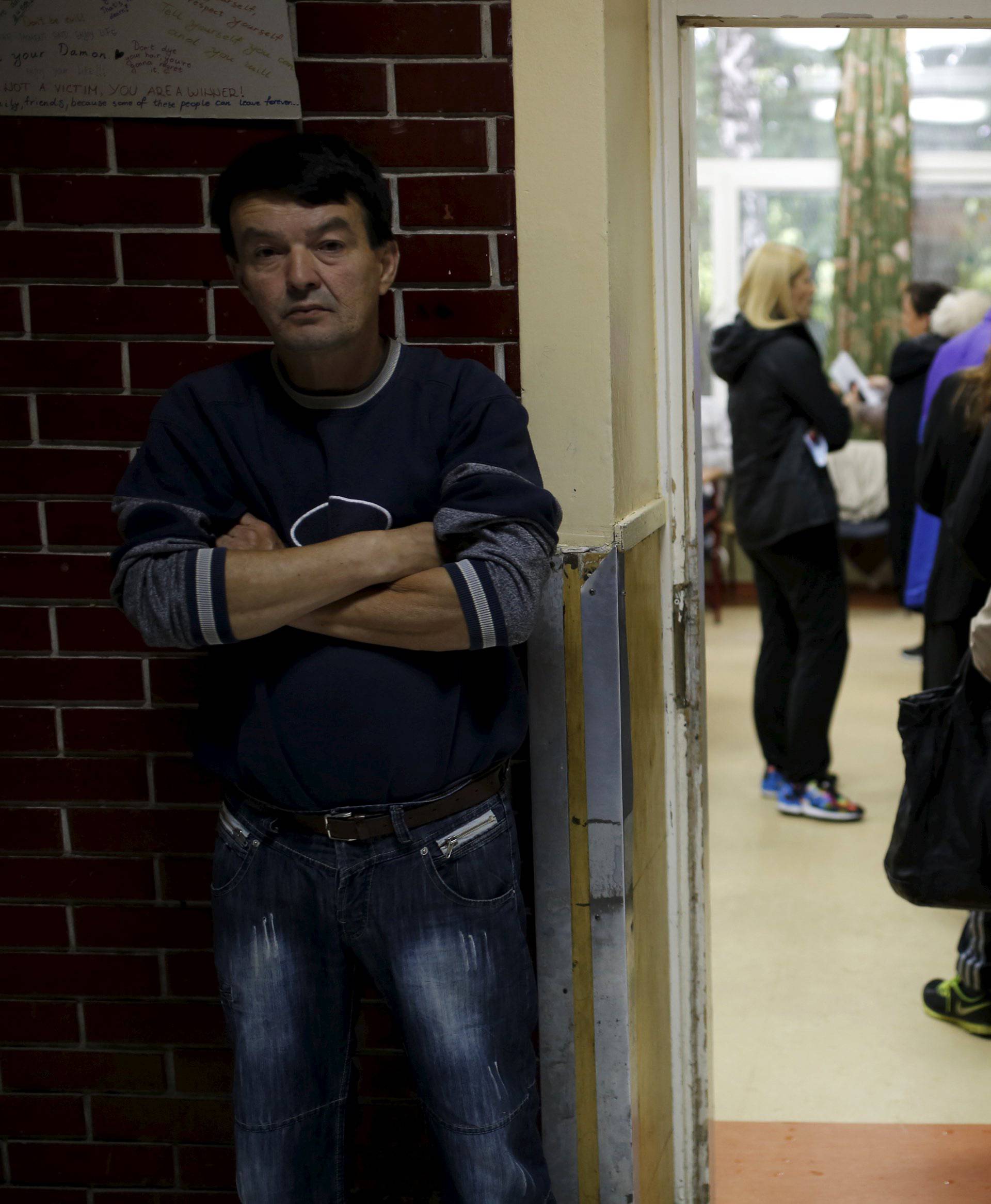 People wait in line to cast their votes at a polling station during elections in Belgrade