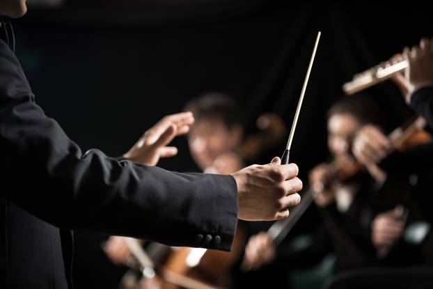 Conductor,Directing,Symphony,Orchestra,With,Performers,On,Background,,Hands,Close-up.