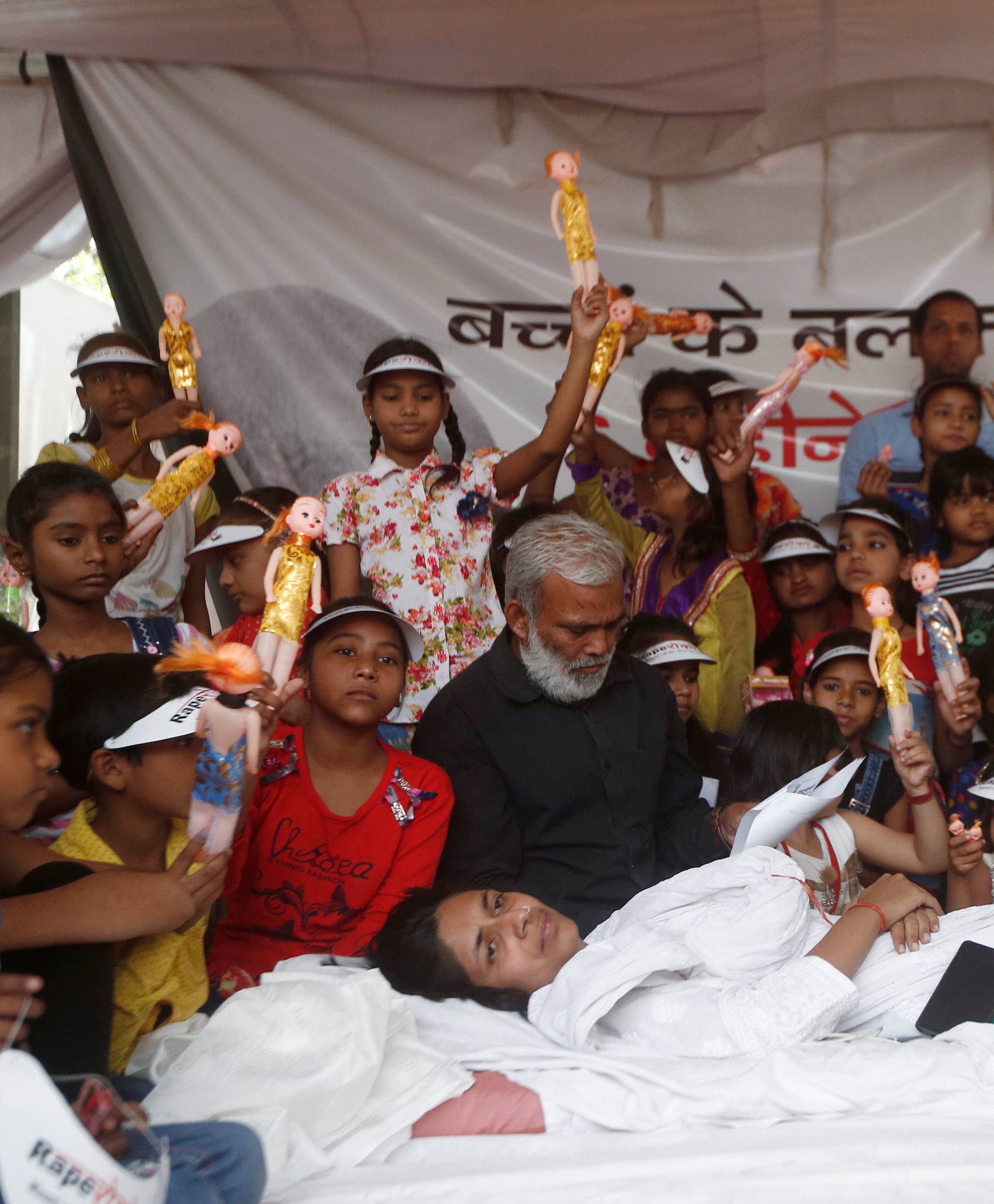 Swati Maliwal, chairperson of Delhi Commission for Women, rests as girls hold dolls during her hunger strike protest demanding stricter laws for rape in India, in New Delhi