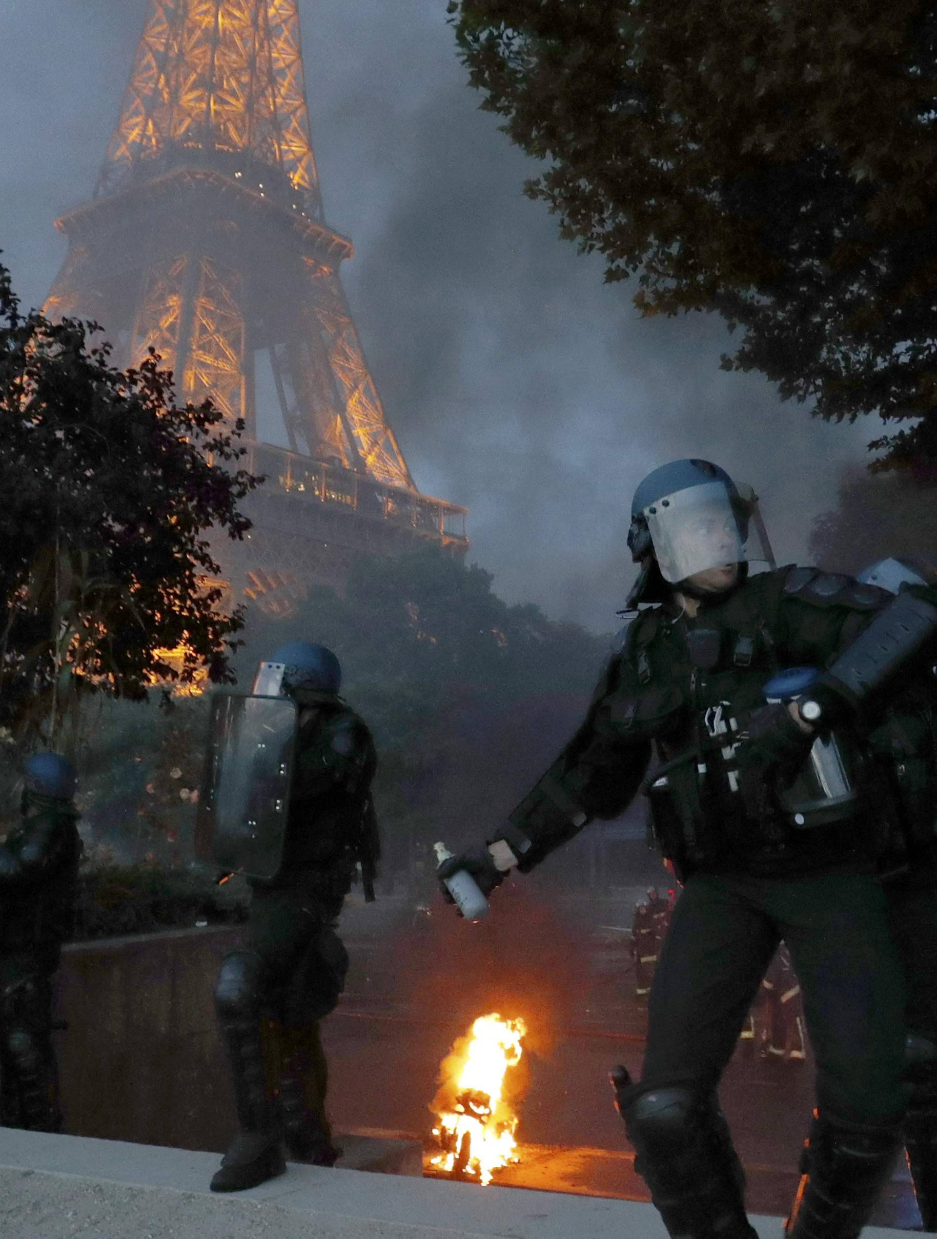 French riot police react with tear gas during clashes outside the Paris fan zone during a EURO 2016 final soccer match       