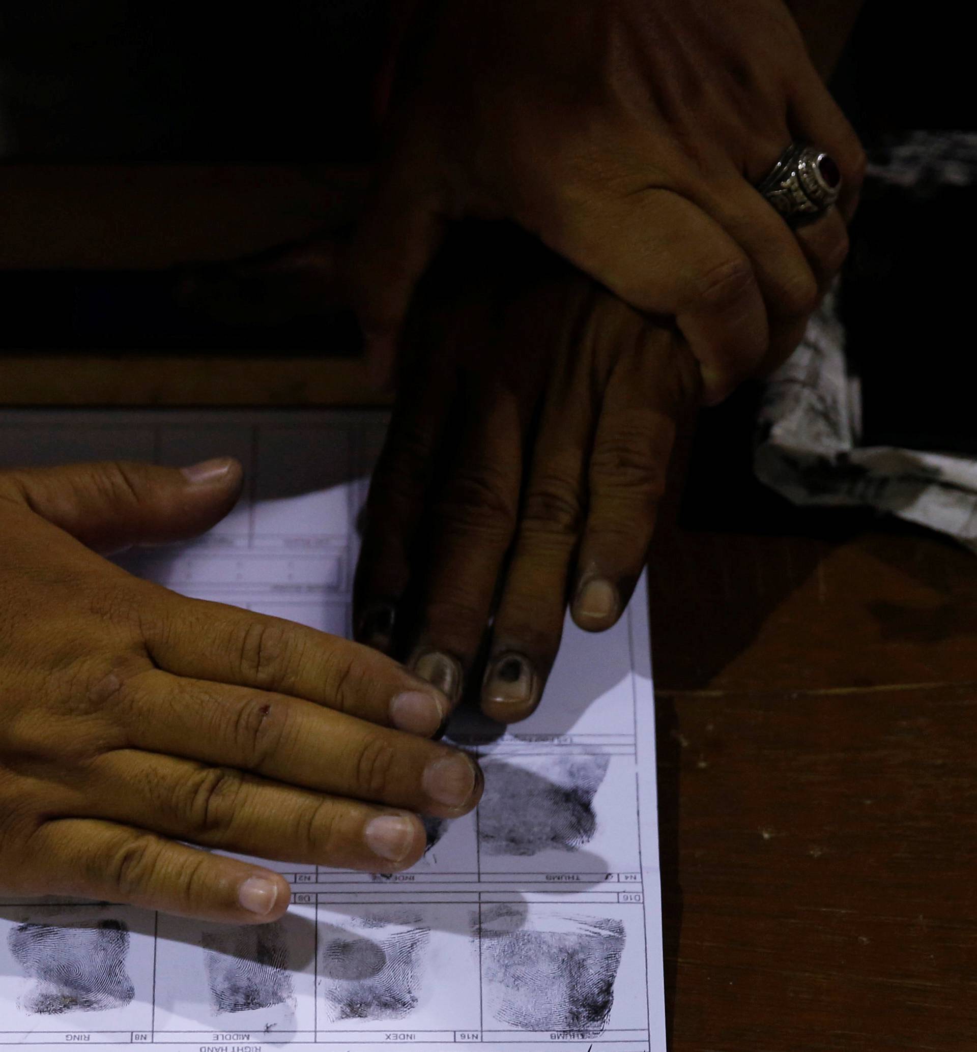 A policeman gets fingerprints of a drug user who surrendered to local government officials to take part in a government campaign against drug in Tanauan Batangas, south of Manila